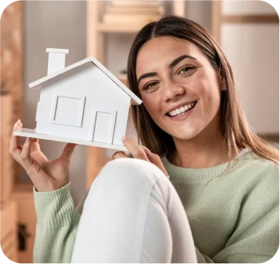 Jovem segurando miniatura de uma casa